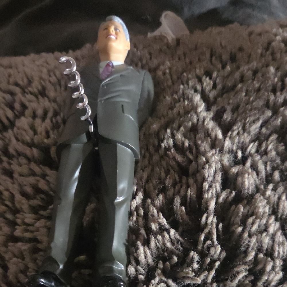 A novelty corkscrew wine opener shaped like a man in a suit / president-style